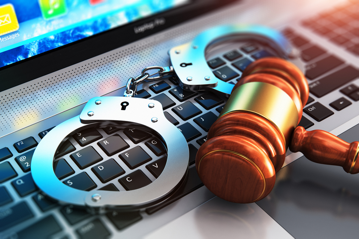 Handcuffs and judge's gavel on a computer keyboard. iGaming States Unite to Urge DOJ Action on Illegal Offshore Sites
